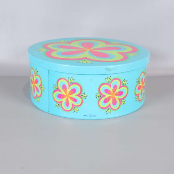 Turkos burk med blommönster sedd från sidan