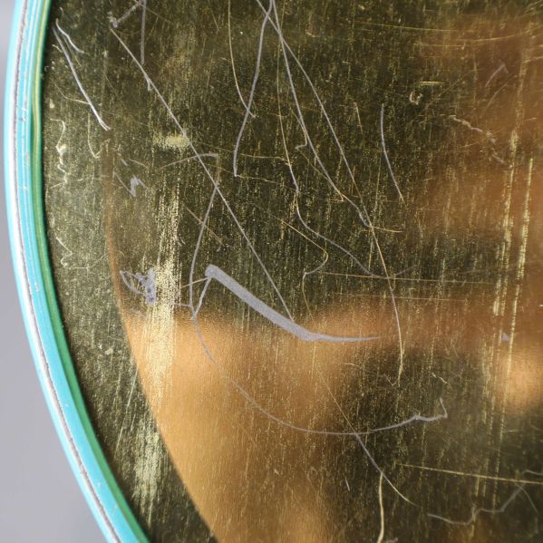 Närbild på botten av burken visar repor på metall