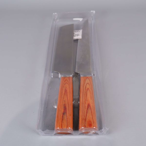 Två köksknivar i plastförpackning tagna snett framifrån