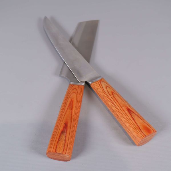 Två köksknivar korslagda med träliknande handtag