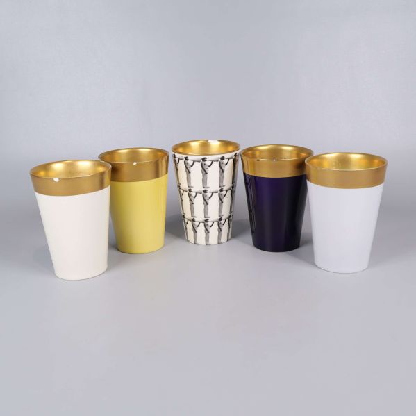 Fem bägare i olika färger och guldkant uppradade