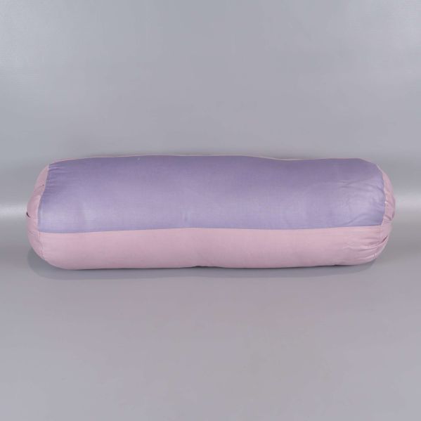 Cylindrisk kudde i ljust lila och rosa liggandes på golv