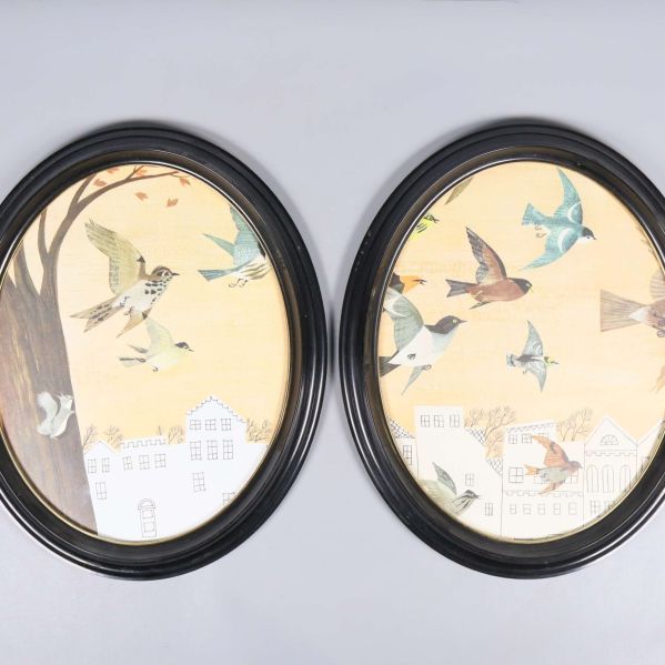 Två stora ovala svarta ramar med fågelmotiv