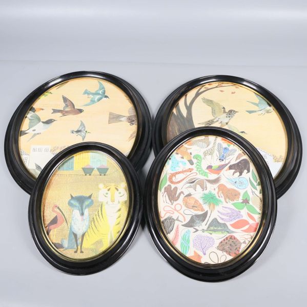 Fyra ovala svarta ramar i grupp med illustrationer