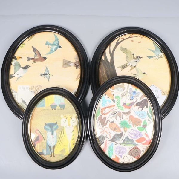 Fyra ovala svarta ramar med djurmotiv