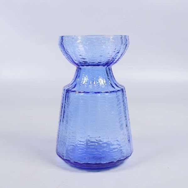 Blå glasvas med strukturyta fotad framifrån