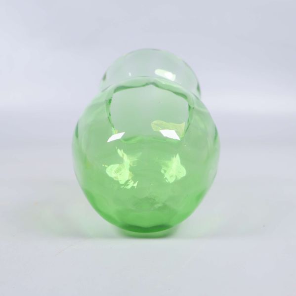 Vasens rundade botten i grönt glas