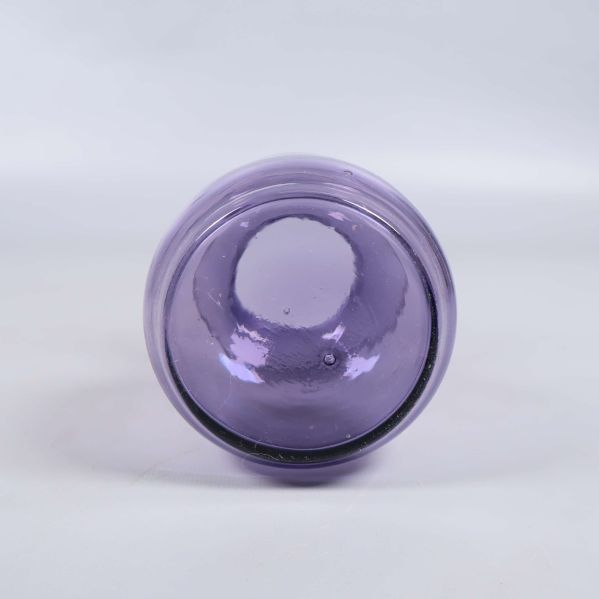 Undersida av blå glasvas mot ljus bakgrund