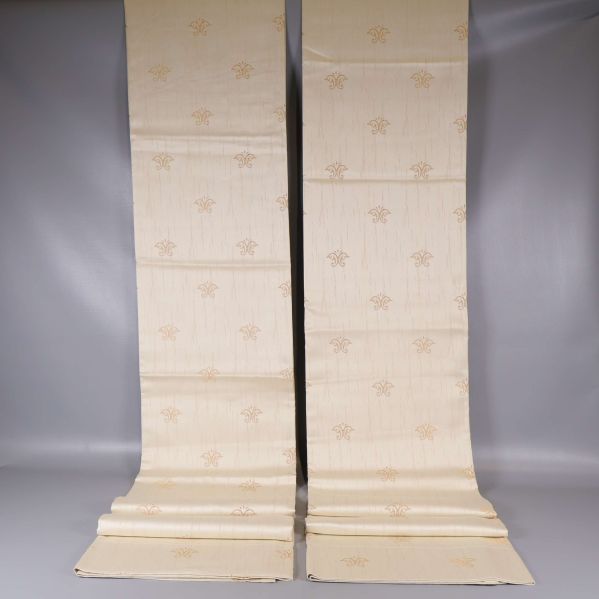 Två långa gardinlängder i ljus textil med mönster