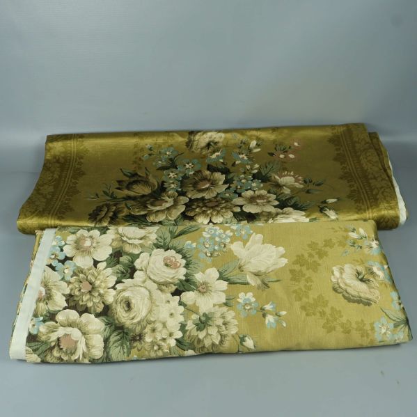 Två hopvikta blommiga draperier i gröna och beige toner