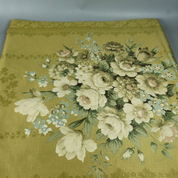 Närbild på draperi med stora blommor och gröna blad