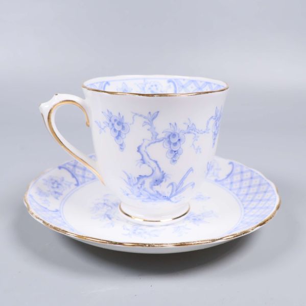 Tekopp med assiett i blåvitt porslin och guldkant