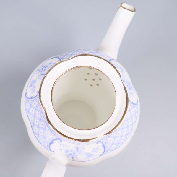 Insidan av blåvit tekanna med gulddetaljer