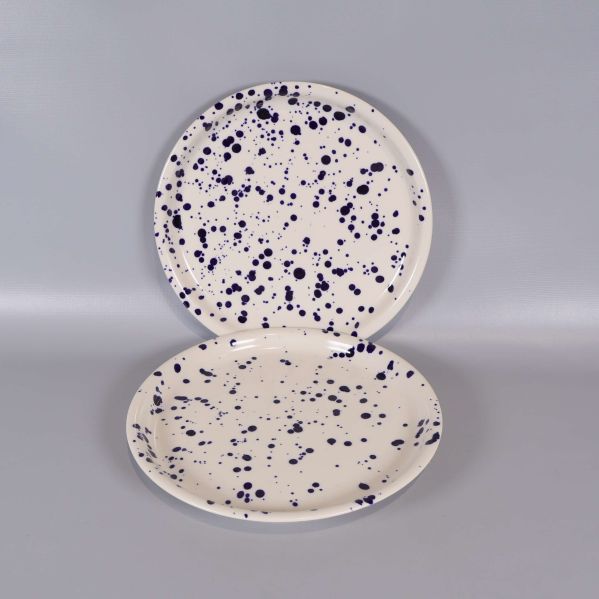 Två upprättstående tallrikar med blå stänk