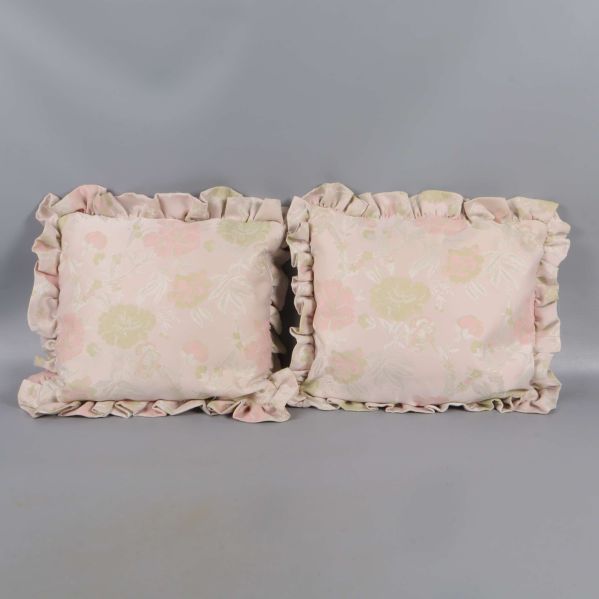 Två rektangulära kuddar med volangkant i blommigt tyg