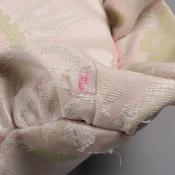 Hörn på kudde med fläck och lös tråd