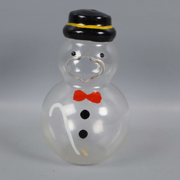 Snögubbe i glas med svart hatt och röd fluga