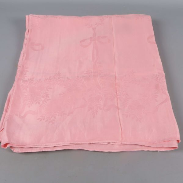 Utbredd rosa duk med vävt blommönster synligt