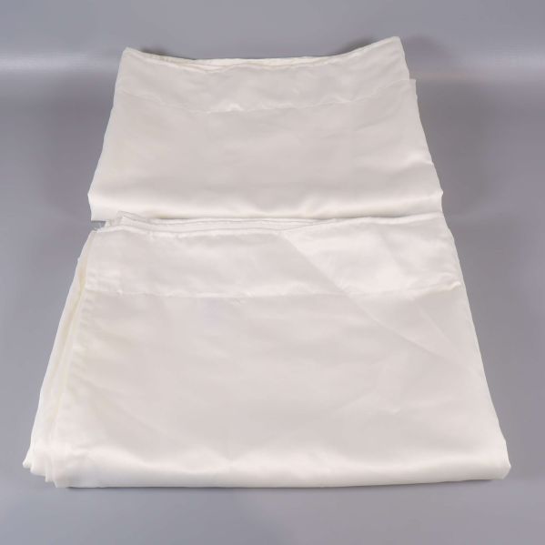 Vikta vita gardiner på grått underlag