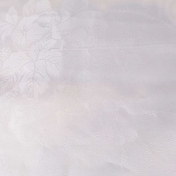 Närbild på tyg med blommigt mönster i vitt