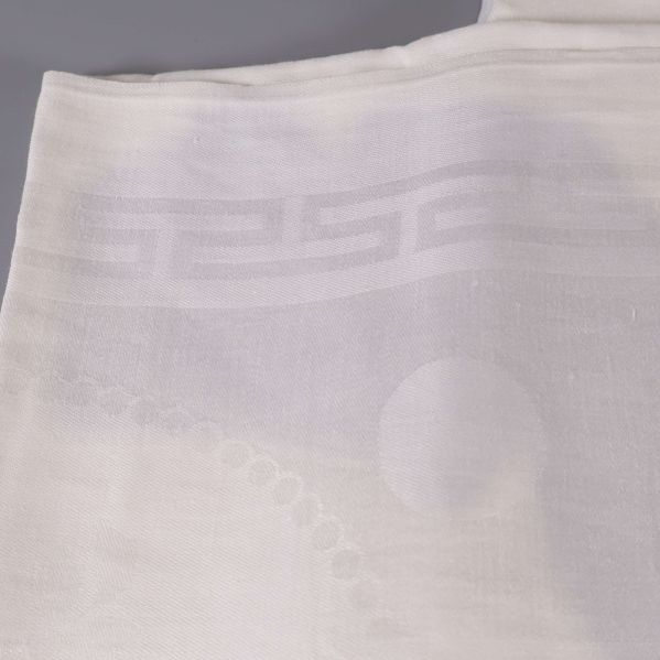 Närbild på invävt mönster i vit duk