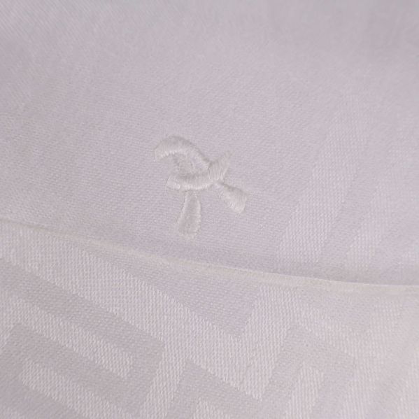 Broderad detalj på vit duk