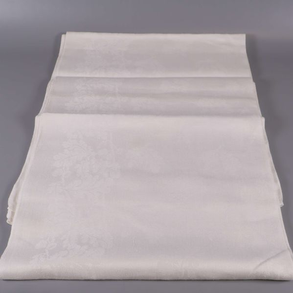 Lång utvecklad vit duk med mönstrad kant