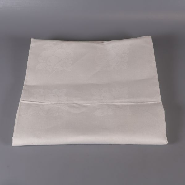 Vikt vit duk i fyrkantig form mot grå bakgrund