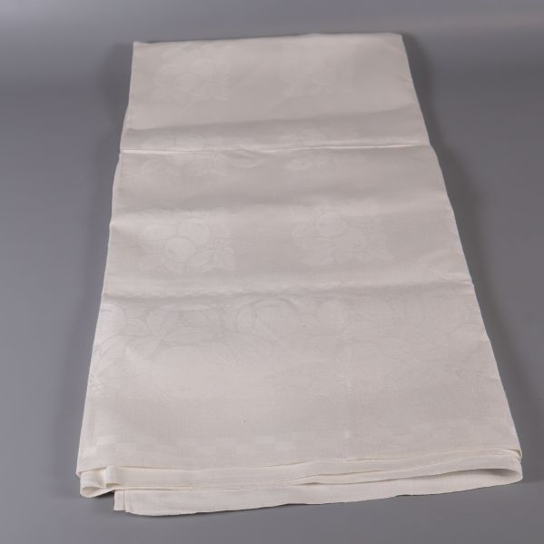 Vit duk utbredd på längden mot grå bakgrund