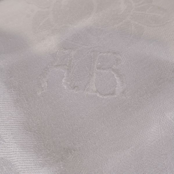 Närbild på initialerna AB invävda i duken