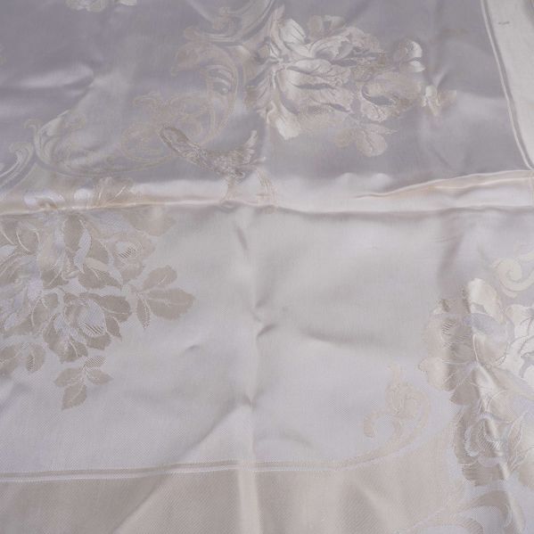 Närbild på dukens glänsande blommönster