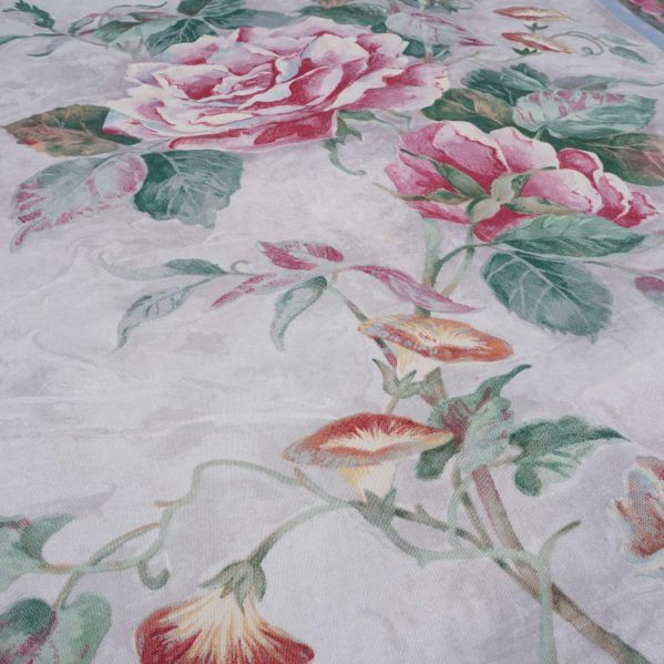 Närbild av stora rosa rosor och gröna blad på tyget