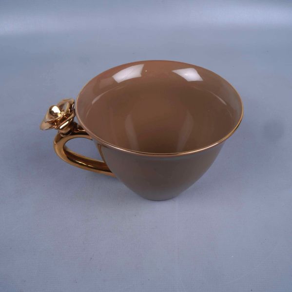 Brun kopp med guldfärgat handtag sedd uppifrån