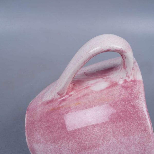 Närbild på koppens handtag och rosa glasyrdetaljer