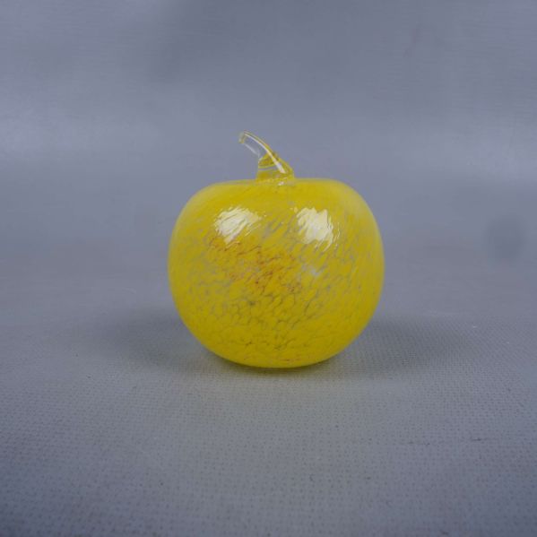 glas figur som är äpple format i gult med stjälk och blanka detaljer