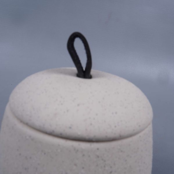 Lock med svart loopgrepp på prickig burk