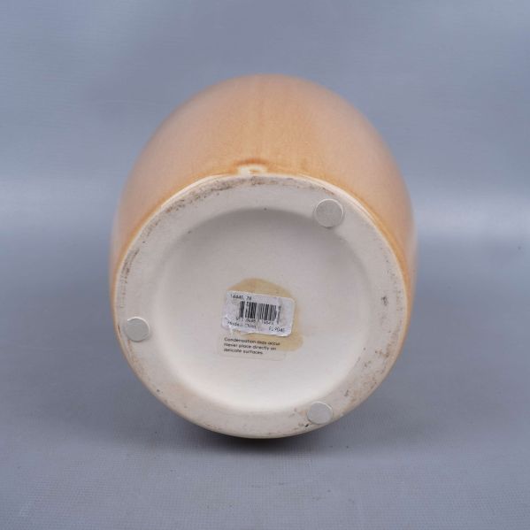 Undersida av vas med produktetikett och tassar