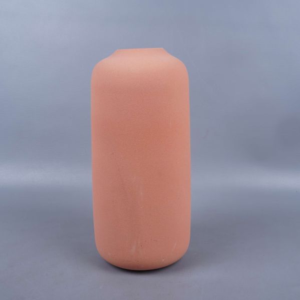 Baksidan av den cylindriska terrakotta färgade vasen