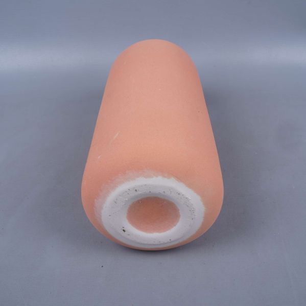 Botten av matt terrakotta färgad vas visas nedifrån