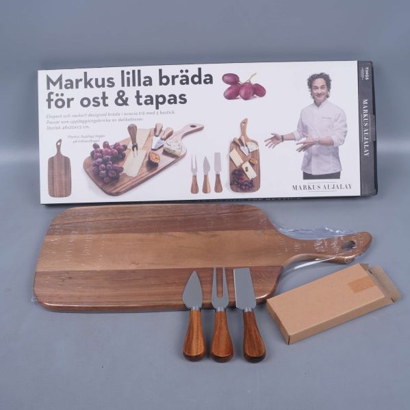 Förpackning till ostbräda med knivar, bräda och knivar synliga