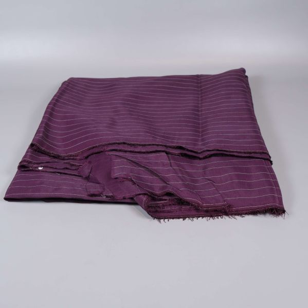 Vikta tygstycken i plommonlila liggande på varann