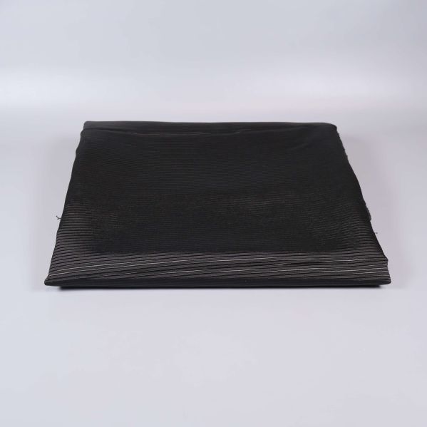 Vikta svarta tygbitar mot ljus bakgrund