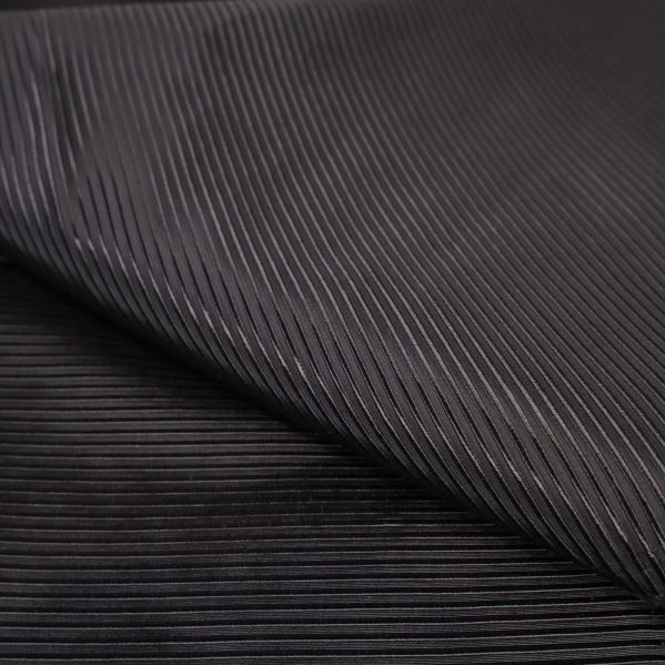 Närbild av ribbad och glansig svart tygtextur