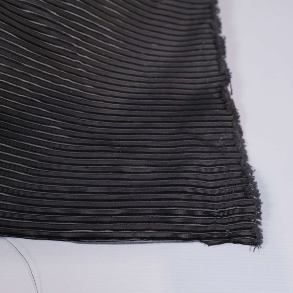 Närbild av fransig tygkant och texturerat mönster