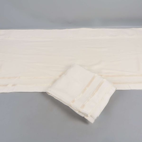 Gardinkappa i naturvit färg utvikt på grå bakgrund