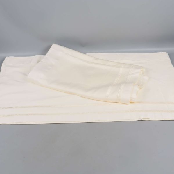 Gardinkappa ihopvikt på grå yta med synliga dekorband