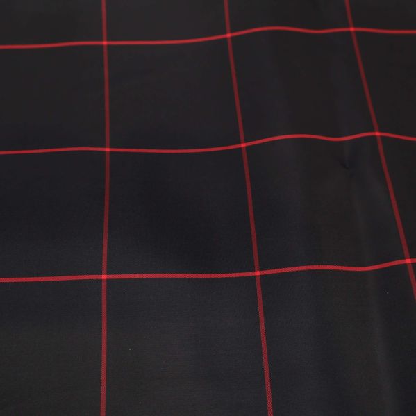 Närbild av svart tyg med rött rutmönster