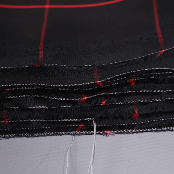 Tygskivor i svart med röda linjer, oklippt kant