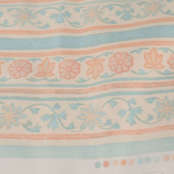 Närbild av tygmönster med blommor och prickar