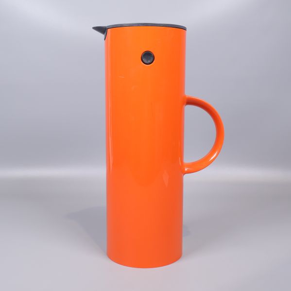 Sidan av termos med tydlig orange färg och svart knapp